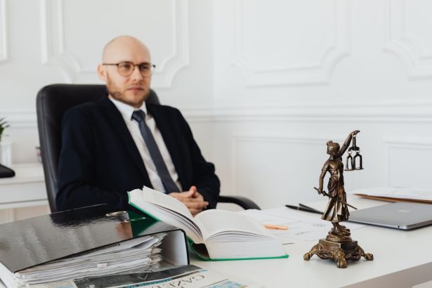 Advogado analisa documentos jurídicos em um escritório, ao lado de uma estátua da Justiça.
