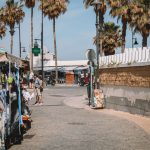 Mercado de souvenirs com visitantes e palmeiras em uma rua de Málaga, na Espanha.